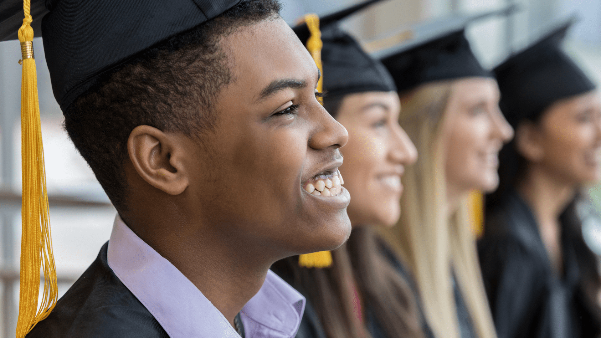 students smiling in graduation caps and gowns