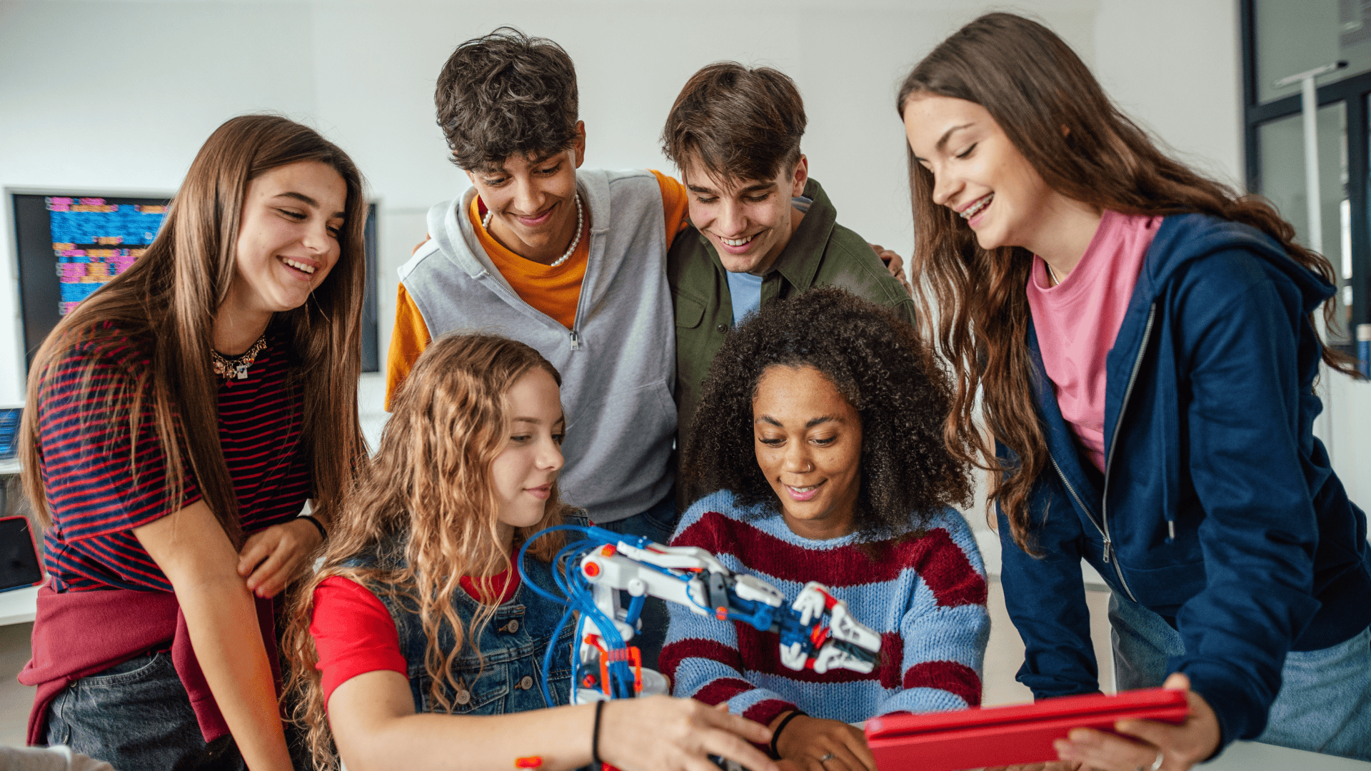high school students grouped around a robotics project
